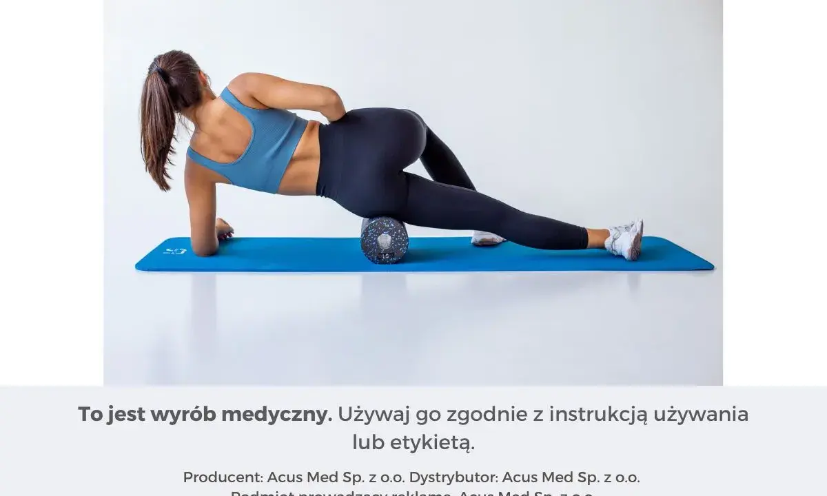 Kobieta wykonuje rolowanie mięśni uda na wałku do masażu, leżąc na macie.
